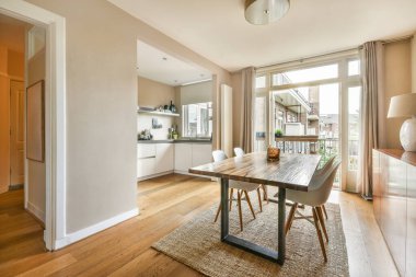 Minimalist tarzı açık mutfağı ve masa ve sandalyeleri olan geniş yemek alanı olan modern çatı katı dairesinin ev tasarımı.