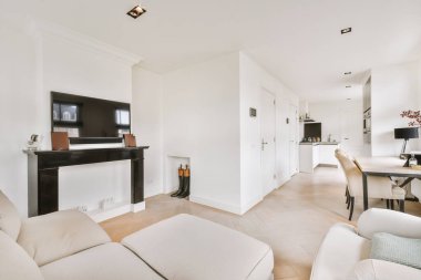 Günümüz minimalist tasarımı. Hafif stüdyo dairesinin ahşap masası ve oturma odası ile beyaz duvarları ve parke zemini arasında yemek masası ve sandalyeleri var.