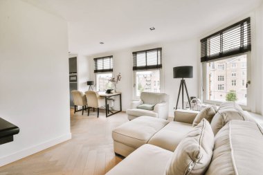 Günümüz minimalist tasarımı. Hafif stüdyo dairesinin ahşap masası ve oturma odası ile beyaz duvarları ve parke zemini arasında yemek masası ve sandalyeleri var.