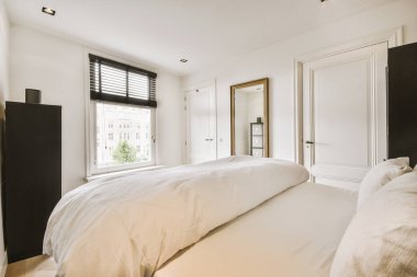 Yatak odasının iç tasarımı, yatak odası ve ahşap gardırop modern dairenin penceresinin kenarına yerleştirilmiş.