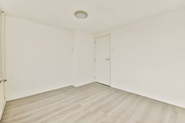 Büyük pencereli ve ahşap parke zeminli boş beyaz odanın içi.