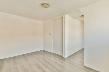 Büyük pencereli ve ahşap parke zeminli boş beyaz odanın içi.