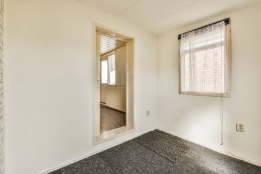 Büyük pencereli ve ahşap parke zeminli boş beyaz odanın içi.