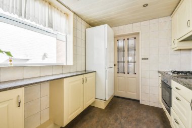 Gündüz vakti modern dolap ve aletlerle donatılmış aydınlık mutfağın içi