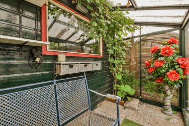 Ahşap çitlerin yanında küçük bahçesi olan basit küçük bir teras.