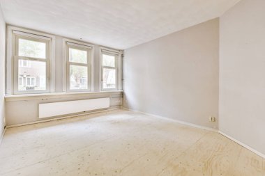 Evdeki boş ışık odasında, beyaz duvardaki plastik pencere ve radyatör.