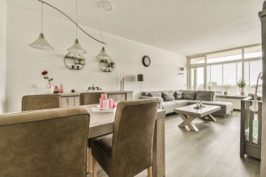 Oturma odasının yanındaki sandalyeli masa ve çağdaş dairenin geniş odasında yemek.