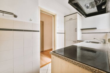 Minimalist tarzı beyaz mobilyalı, lavabolu ve sobalı bir ev mutfağı.