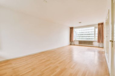 Evdeki boş ışık odasında, beyaz duvardaki plastik pencere ve radyatör.