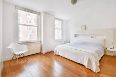 Yatak odasının iç tasarımı, yatak odası ve ahşap gardırop modern dairenin penceresinin kenarına yerleştirilmiş.