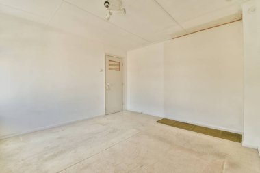 Evdeki boş ışık odasında beyaz duvarda perdeleri ve radyatörü olan plastik bir pencere.