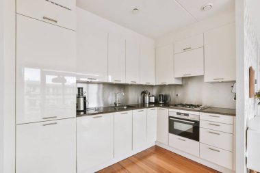 Günümüz minimalist tasarımı. Hafif stüdyo dairesinin ahşap masası ve oturma odası ile beyaz duvarları ve parke zemini arasında yemek masası ve sandalyeleri var.