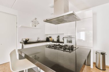 Minimalist tarzı beyaz mobilyalı, lavabolu ve sobalı bir ev mutfağı.