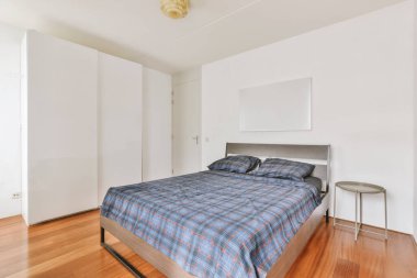 Yatak odasının iç tasarımı, yatak odası ve ahşap gardırop modern dairenin penceresinin kenarına yerleştirilmiş.