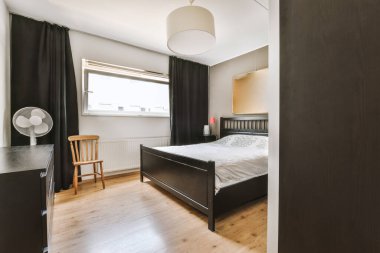 Yatak odasının iç tasarımı, yatak odası ve ahşap gardırop modern dairenin penceresinin kenarına yerleştirilmiş.