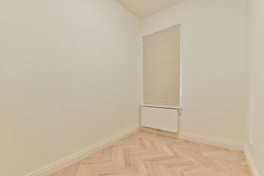 Evdeki boş ışık odasında, beyaz duvardaki plastik pencere ve radyatör.
