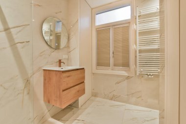 Evdeki modern tuvalette asılı duran banyo musluğu ile duvar arasındaki cam bölme.