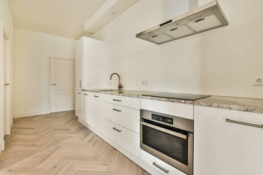 Koridoru ve ahşap parke zemini olan boş mutfağın içi.