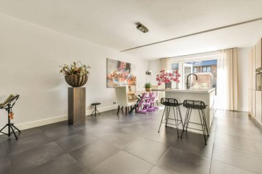 Minimalist tarzı açık mutfağı ve masa ve sandalyeleri olan geniş yemek alanı olan modern çatı katı dairesinin ev tasarımı.