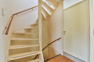 Çağdaş apartmanın koridorundaki kapı ve tuğla duvarın yanında bulunan merdiven ve asansör.