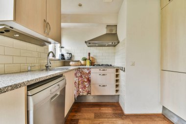 Oturma odasında geniş mutfak ve yemek masaları var.