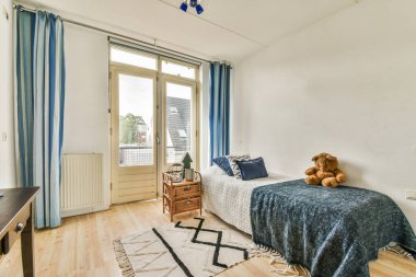 Rahat bir yatak, beyaz çarşaflar ve hafif yatak odasındaki komodinli.