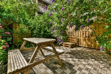 Neat powerful patio with sitting area and small garden near wooden fence