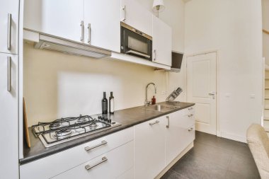 Minimalist tarzı açık mutfağı ve masa ve sandalyeleri olan geniş yemek alanı olan modern çatı katı dairesinin ev tasarımı.