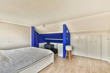 Evin penceresinin yanında rahat bir yatak ve balkon kapısı var.