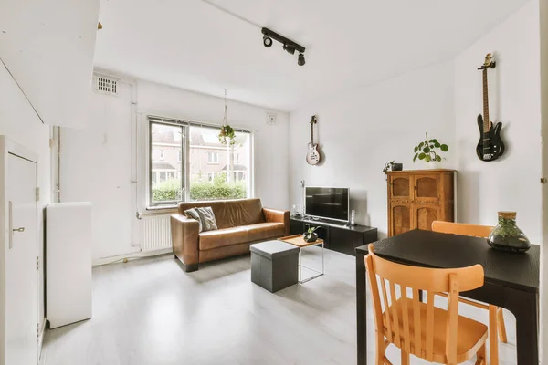 现代公寓有舒适沙发和靠窗看电视的客厅室内 — 图库照片