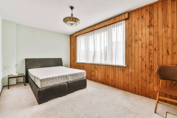 现代公寓靠窗的角落布置有床 木衣橱的居室室内设计 — 图库照片