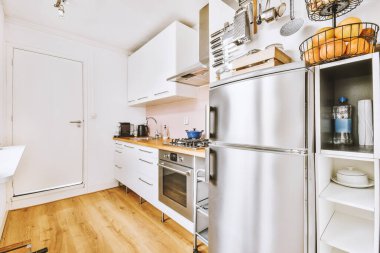 Minimalist tarzı beyaz mobilyalı, lavabolu ve sobalı bir ev mutfağı.