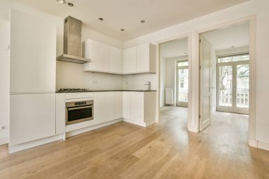 Çağdaş sayaçlar ve tabureler evdeki geniş ışıklı mutfakta şık egzoz kapağının altında.