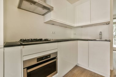 Çağdaş sayaçlar ve tabureler evdeki geniş ışıklı mutfakta şık egzoz kapağının altında.