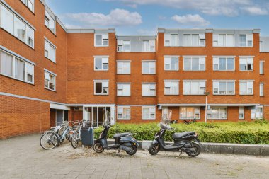 Ağaçlar ve fenerlerle dolu boş bir kaldırım sokağından tuğla evler manzarası