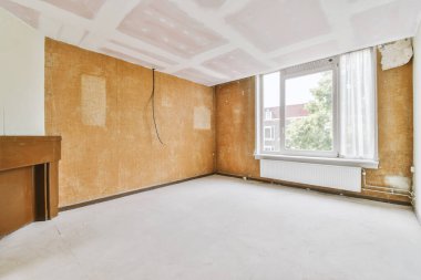 Evdeki boş ışık odasında, beyaz duvardaki plastik pencere ve radyatör.