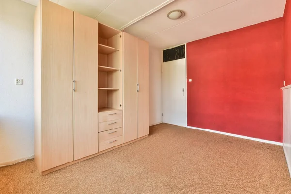 cupboard placed near doors with red and white walls