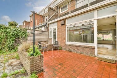 Neat powerful patio with sitting area and small garden near wooden fence