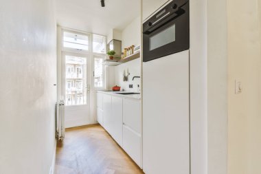 Minimalist tarzı beyaz mobilyalı, lavabolu ve sobalı bir ev mutfağı.