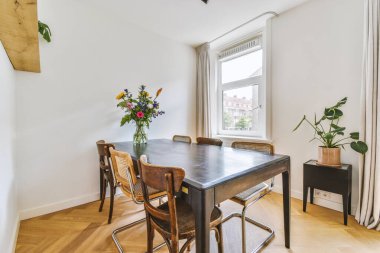 Modern apartmandaki dekorasyonlu ve televizyonlu, rahat koltuğun yanına yerleştirilmiş eski püskü ahşap masa.