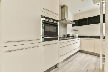 Gündüz vakti küçük pencerenin yanında modern dolap ve aletlerle donatılmış aydınlık mutfağın içi