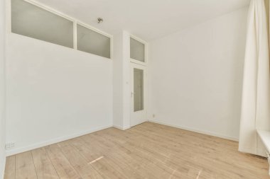 Büyük balkon pencereli, perdeli ve ahşap parke zeminli boş beyaz odanın içi.