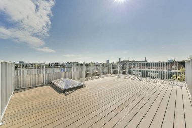 Üçgen şekilli çatısı ve gün ışığında ahşap kirişleri olan açık planlı stüdyo daire.