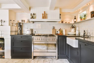 Minimalist tarzı siyah mobilyalı, lavabolu ve sobalı bir ev mutfağı.