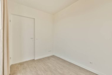 Beyaz duvarları ve parke zemini lambayla aydınlatılmış boş, modern bir daire.