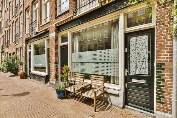 Arabaları, ağaçları ve fenerleri olan boş bir kaldırımdan panorama manzaralı evler.