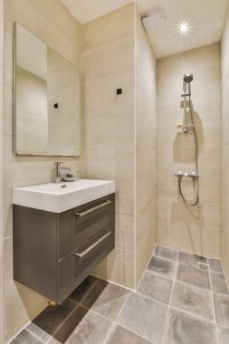 Duşu olan ve düz bir şekilde lavaboya batan çağdaş bir banyo.