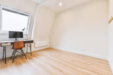 Boş tahtaya karşı bilgisayar monitörleri ve çağdaş düz ofisteki hafif ev yapımı savaş uyuşturucusuna karşı masanın yanına yerleştirilmiş rahat sandalye