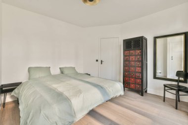 Balkon kapısının yanında rahat bir yatak, evdeki rahat yatak odasında perdeler var.