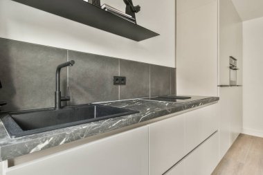 Mutfağın yakınındaki açık oturma odasındaki şöminenin yanındaki zarif avizenin altında yumuşak yastıklı büyük bir kanepe.